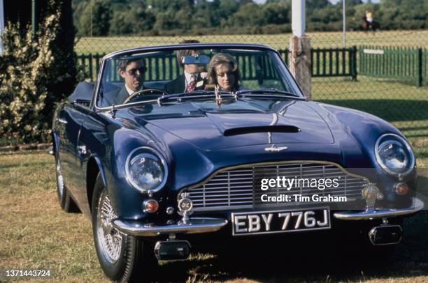 Charles, Prince of Wales and his girlfriend, Caroline Longman, in Charles' Aston Martin V8 Volante convertible sports car after attending an polo...