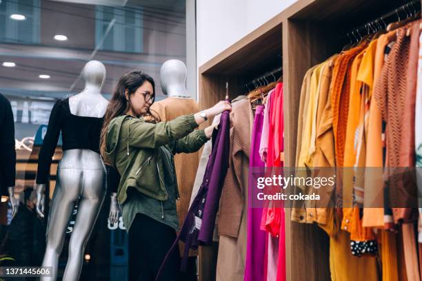 woman shopping for clothes - clothing store stockfoto's en -beelden