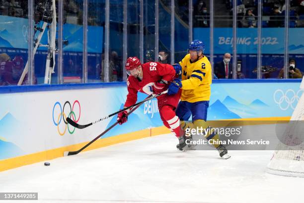 Anton Slepyshev of Team ROC and Christian Folin of Team Sweden compete during the Men's Ice Hockey Playoff Semifinal match between Team ROC and Team...