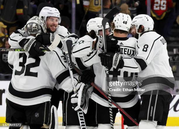 Adrian Kempe of the Los Angeles Kings hugs teammate Jonathan Quick as they celebrate on the ice after Kempe scored a goal in overtime to defeat the...