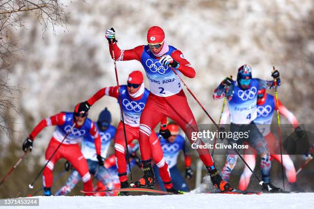 Alexander Bolshunov of Team ROC competes ahead of Ivan Yakimushkin of Team ROC and Simen Hegstad Krueger of Team Norway during the Men's...