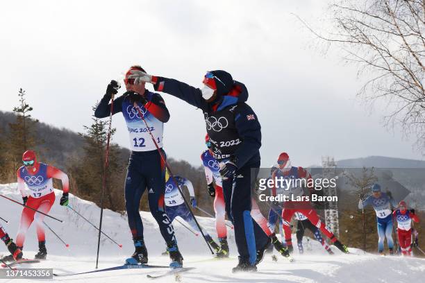 Andrew Musgrave of Great Britain receives a drink while competing during the Men's Cross-Country Skiing 50km Mass Start Free on Day 15 of the Beijing...