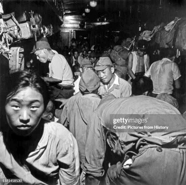 Demobilized Japanese soldiers and civilians crowd into passenger cars aboard trains bound for Tokyo following the surrender of the Empire of Japan to...