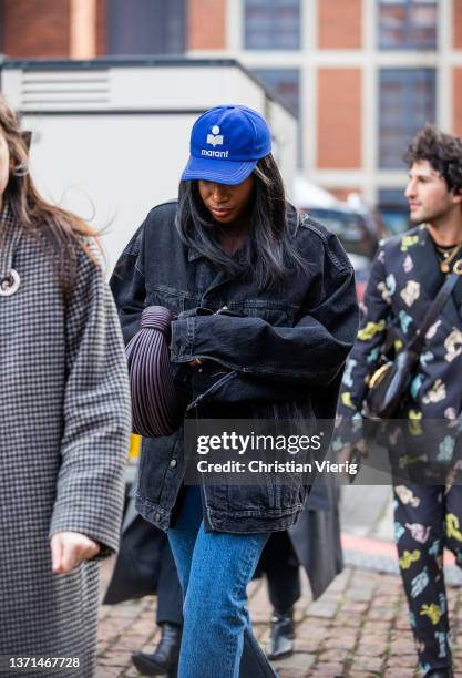 Guest is seen wearing dark denim jacket, blue Marant cap, bag, denim jeans outside Bora Aksu during London Fashion Week February 2022 on February 18,...