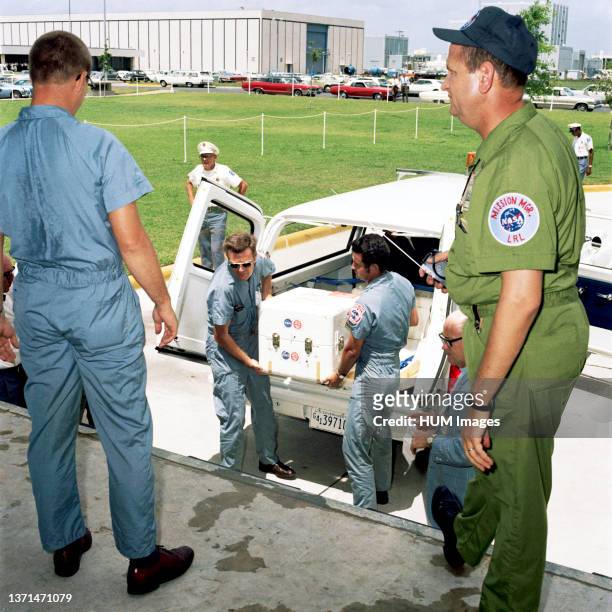 The first Apollo 11 sample return container, with lunar surface material inside, is unloaded at the Lunar Receiving Laboratory, Building 37, Manned...