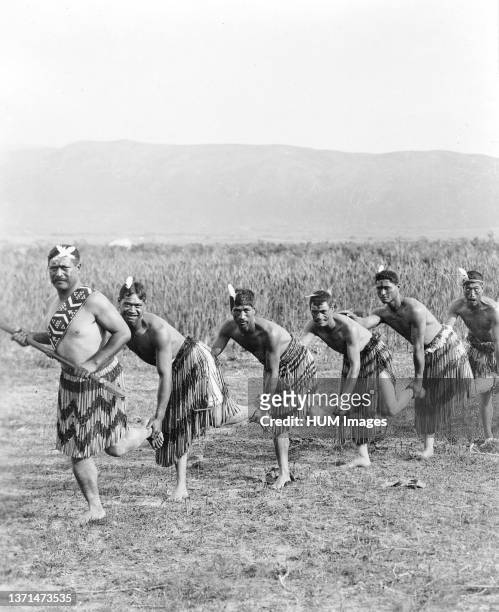 Five Maori men posing in traditional clothing doing haka dance 1890-1920.