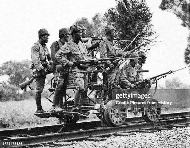 Japanese Imperial Army soldiers with Arisaka Type 38 rifles on a railway hand cart, China, 1937. Asahigraph, September 1937.