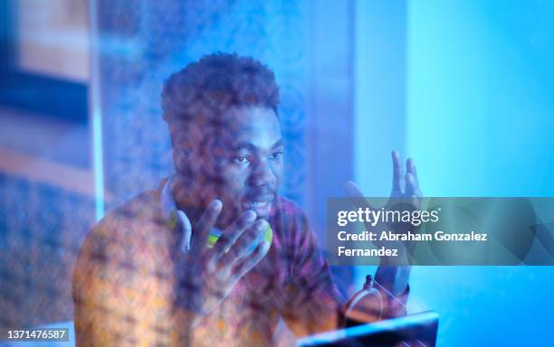 young streamer performing chat session together with his followers in live streaming with blue light around - social media followers stock pictures, royalty-free photos & images