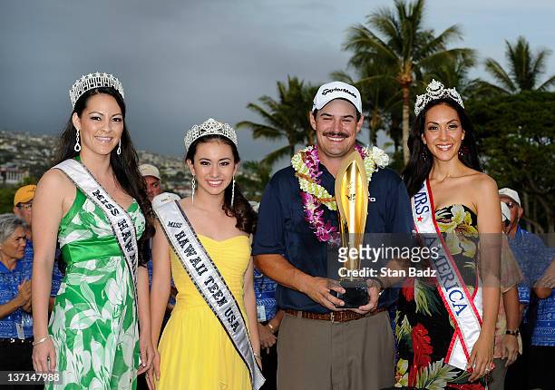 Johnson Wagner poses with the tournament trophy and Hawaiian beauty queens on the 18th green after winning the Sony Open in Hawaii at Waialae Country...