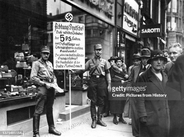 Members of the SA in front of a Jewish shop on April 1, 1933. The sign says: 'Germans, Attention! This shop is owned by Jews. Jews damage the German...