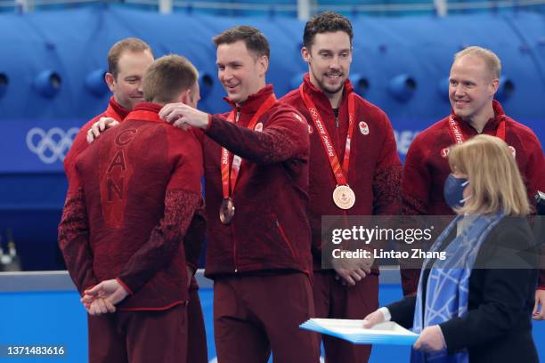 Brad Gushue of Team Canada places a bronze medal on team mate Marc Kennedy of Team Canada during the Men's Curling Medal Ceremony on Day 14 of the...