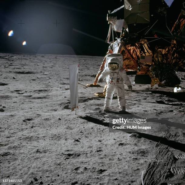 Lunar Module Pilot Edwin 'Buzz' Aldrin standing next to the Solar Wind Composition experiment, part of the Early Apollo Scientific Experiments...