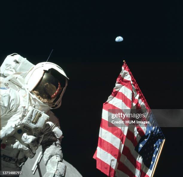 Astronaut Harrison Schmitt poses on the Lunar surface next to an American flag during Apollo 17. .