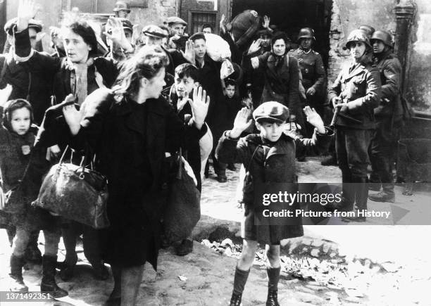 Jewish men, women and children surrender to Nazi soldiers during the Warsaw Ghetto Uprising, May 1943.