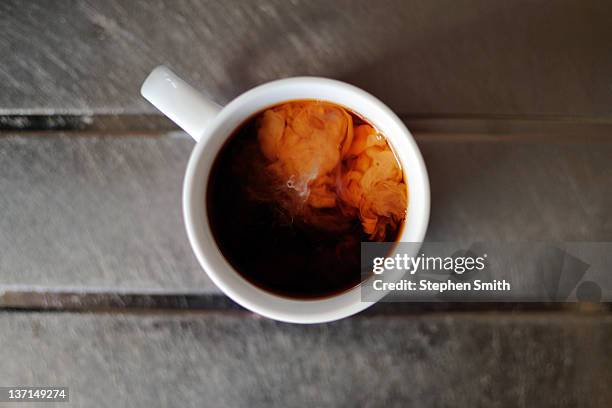 splash of milk added to cup of english tea - black tea stock pictures, royalty-free photos & images