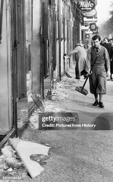 Shopkeeper cleans up broken glass after Kristallnacht, 10 November, 1938.