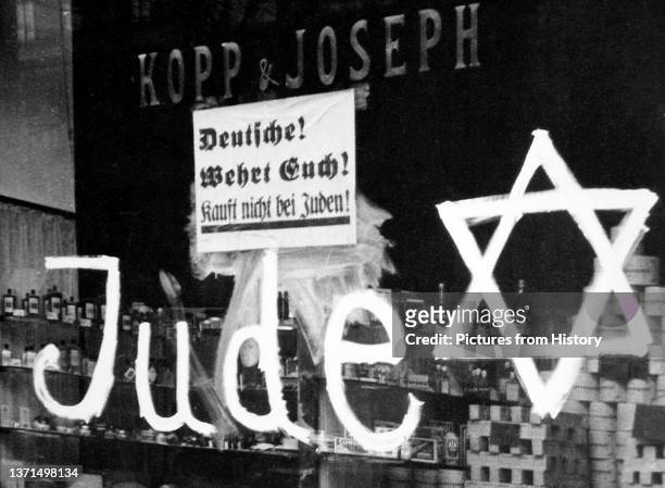 Jewish-owned shop vandalized by Nazis with poster reading 'Germans Defend Yourselves - Don't Buy from Jews', 1938.