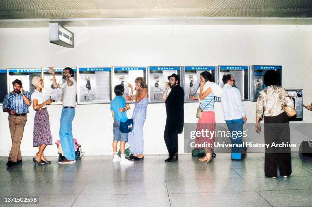 Group of People using Pay Telephones, LaGuardia Airport, Queens, New York, USA, Bernard Gotfryd, October 1981.
