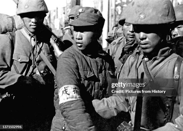 Imperial Japanese soldiers flank a Chinese soldier captured at the Battle of Nanking prior to his execution, December 1937.