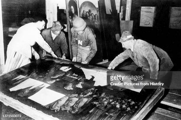 Monuments Men examining Jan van EyckÕs Ghent Altarpiece at the Altaussee salt mine, Styria, central Austria, 1945.