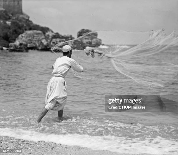 Caesarea. . Fisherman throwing his net in the harbour ca. 1938