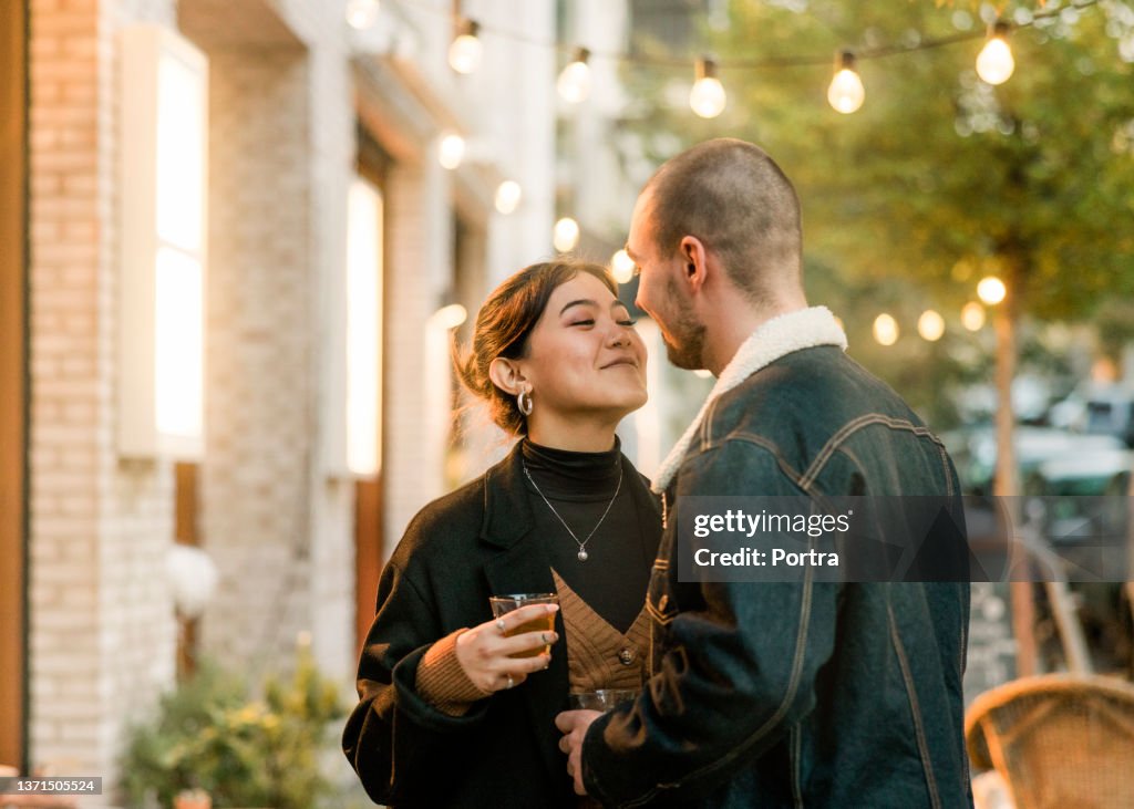 Couple in love about to kiss outside a coffee shop in the city
