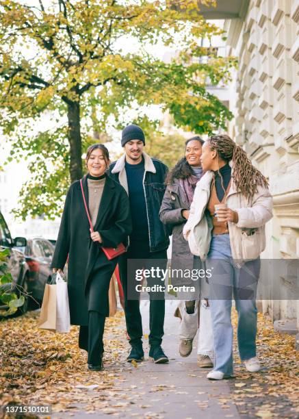 friends holding shopping bags walking in the city - berlin winter stockfoto's en -beelden