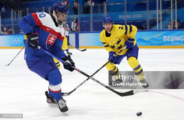 Juraj Slafkovsky of Team Slovakia is challenged by Christian Folin of Team Sweden in the first period during the Men's Ice Hockey Bronze Medal match...