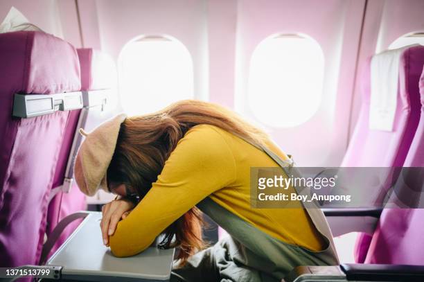 tourist woman sleeping/napping on plane during long flight. - woman sleeping table stock pictures, royalty-free photos & images