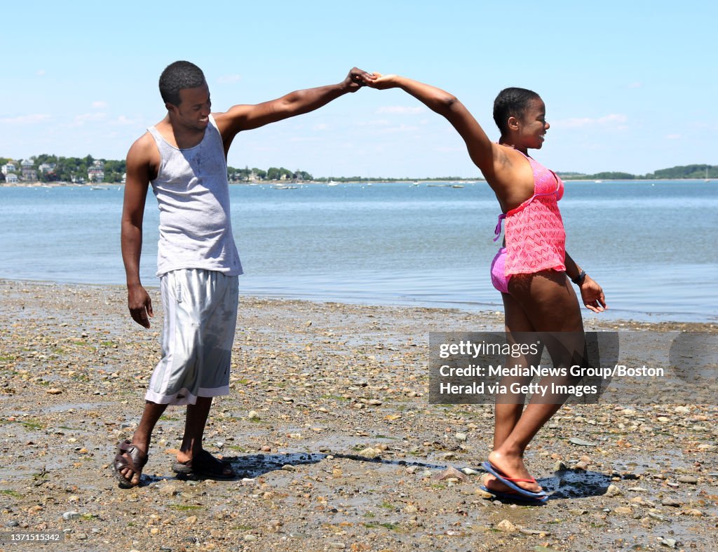 (Quincy, MA - 6/10/15) Sony Saint-Hubert of Randolph gives Farah Clermont of Medford a twirl at Wollaston Beach, Wednesday, June 10, 2015. Staff photo by Angela Rowlings.