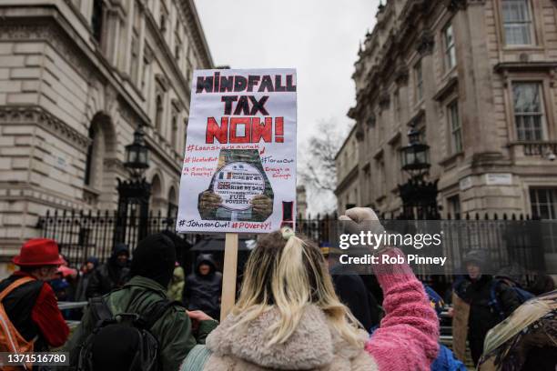 Protester carrying a sign calling for a windfall tax outside Downing Street on February 19, 2022 in London, England. #Take Back Democracy are...