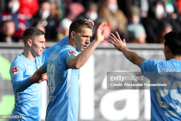 Nils Petersen of SC Freiburg celebrates with teammates after scoring their team's first goal during the Bundesliga match between FC Augsburg and...