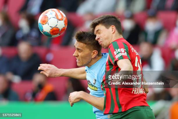 Nils Petersen of SC Freiburg and Raphael Framberger of FC Augsburg compete for a header during the Bundesliga match between FC Augsburg and...