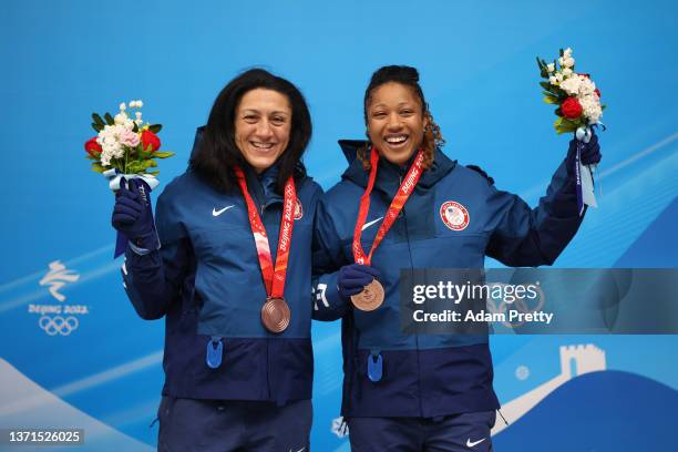 Bronze medal winners Elana Meyers Taylor and Sylvia Hoffman of Team United States pose for a photo with their medals during the flower ceremony...