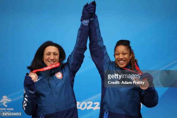 Bronze medal winners Elana Meyers Taylor and Sylvia Hoffman of Team United States pose for a photo with their medals during the flower ceremony...