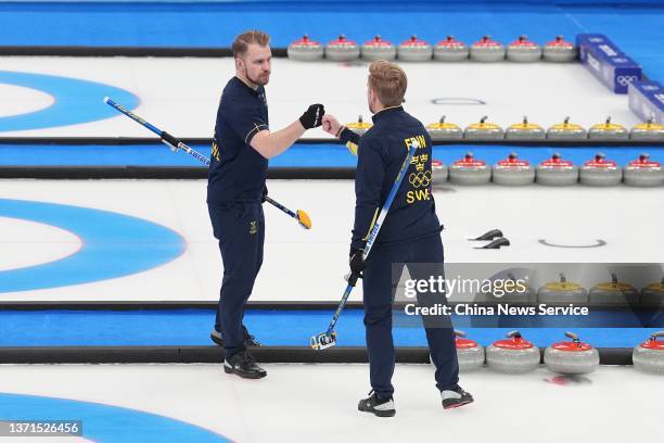 Niklas Edin of Team Sweden fist bump with his teammate Rasmus Wranaa during the Men's Curling Gold Medal Game between Team Sweden and Team Great...