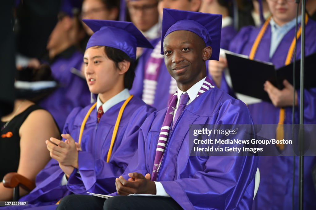 Class valedictorian Nathan Han, left, and president Ado JeanNoel sit