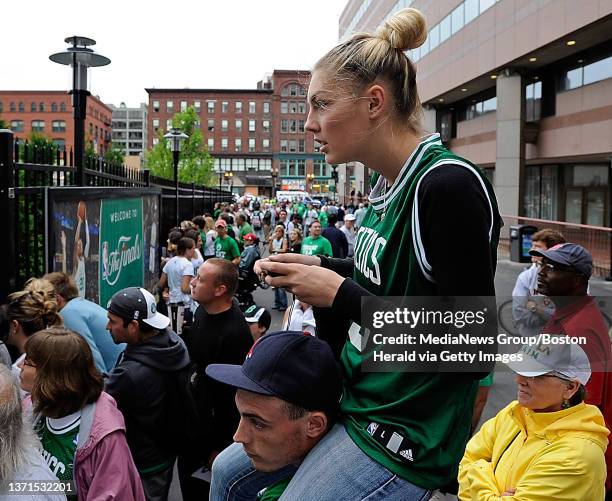 Jessica Nadolny of Newton, sits on Waltham resdent Nick Cranmer's shoulder as they try catch a glimpse of Celtics players as they arrive prior to the...