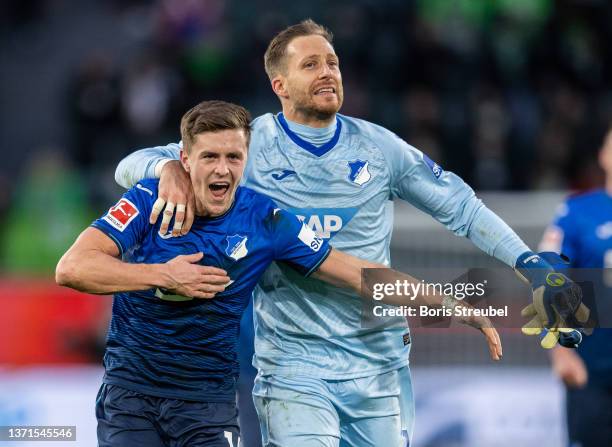 Christoph Baumgartner of TSG Hoffenheim and goalkeeper Oliver Baumann of TSG Hoffenheim celebrate after winning the Bundesliga match between VfL...