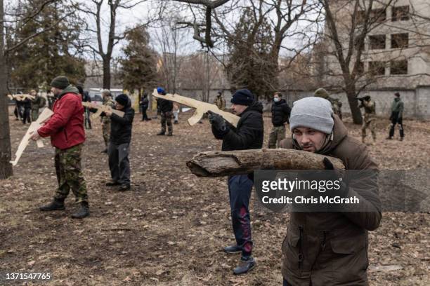 Civilian uses a log as a gun during a military training course conducted by a Christian Territorial Defence Unit on February 19, 2022 in Kyiv,...