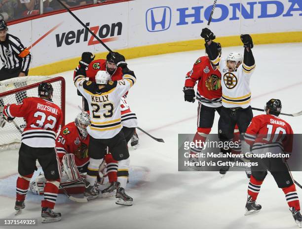 Boston Bruins left wing Daniel Paille helps center Chris Kelly celebrate his second period goal against the Chicago Blackhawks in Game 2 of the...