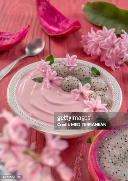 pitahaya and strawberry yogurt breakfast bowl, mint leaves, pink flowers decoration on pink wood table - dragon fruit stock pictures, royalty-free photos & images