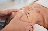 Closeup shot of a mature woman enjoying a relaxing head massage at a spa