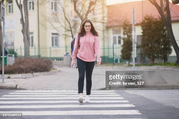 a teenage girl (16-17 years) crossing the street - 16 17 years imagens e fotografias de stock