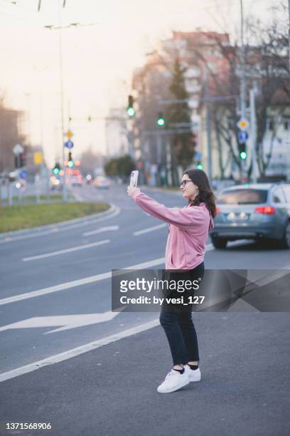 a teenage girl (16-17 years) taking a selfie in the city - 14 15 years girls stockfoto's en -beelden