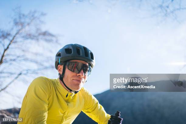 un cycliste de route se détend dans un parc urbain ensoleillé - lunettes de pilote de course photos et images de collection