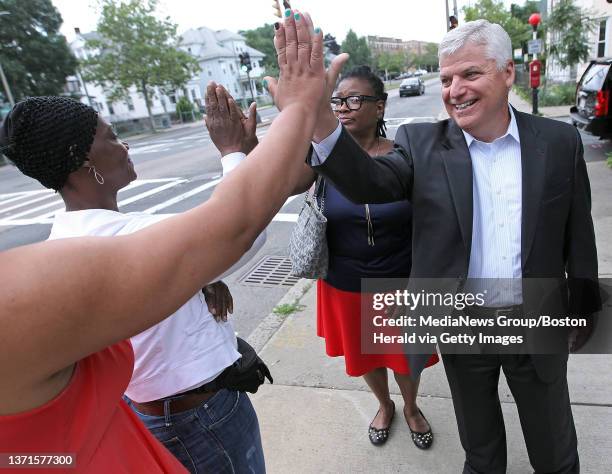 Women's homicide survivor advocate Mary Franklin and Suffolk County District Attorney Daniel F. Conley high five Eliasha James, not seen and Carrie...