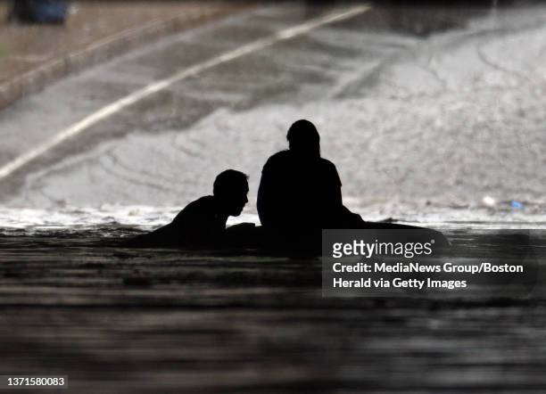 Off duty Somerville firefighter Michael Marino swims out to save Christine Broderick, 45 of Somervill, after her car became trapped in rain water...
