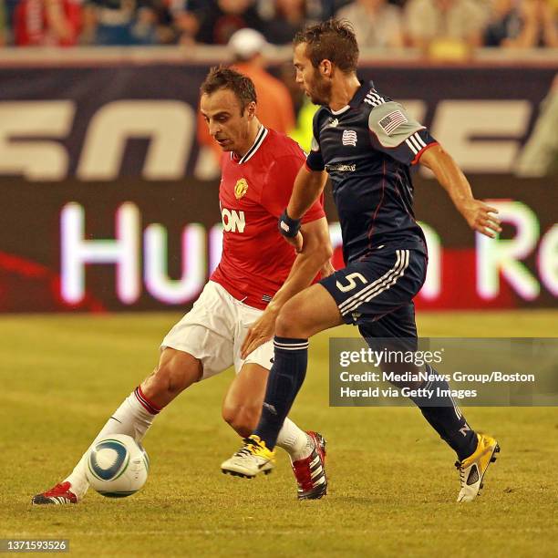 Manchester United forward Dimitar Berbatov works the ball up the field against New England Revolution defender AJ Soares as the Revolution take on...