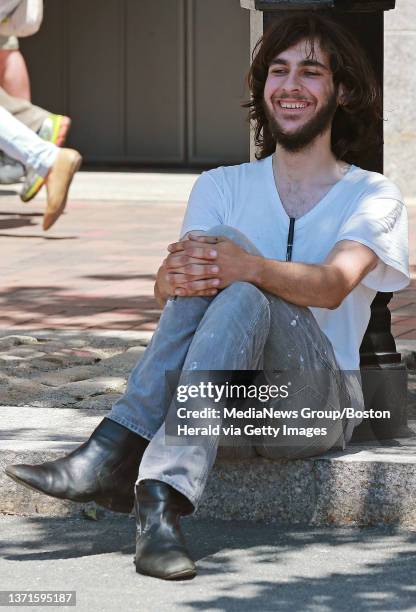 An unidentified man who was later taken into custody laughs as a search is conducted on his car parked without license plates attached parked outside...